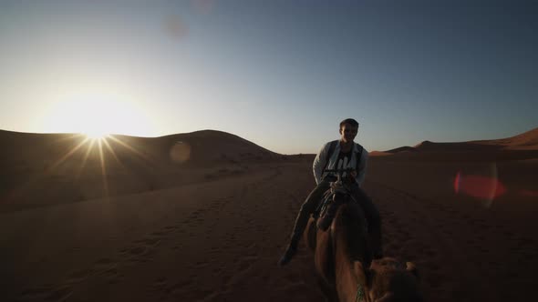 View of Mid Adult Man Riding on Camel in Desert