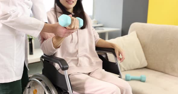 Resuscitator Helps Woman in Wheelchair to Do Exercises with Dumbbells