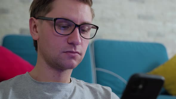 Man Write a Message Using a Mobile Phone, Staying Isolated at Home