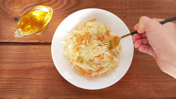 Sauerkraut on white plate wooden table. Pickled cabbage carrot Fermented by lactic acid vegetables