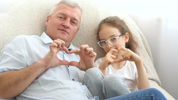 Mature Handsome Man and Little Blonde Girl are Showing Hearts By Hands Happy Family Togetherness