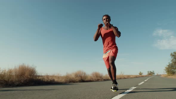 AfricanAmerican Black Man Athlete is Running Down Road and Boxing Background Sky Low View