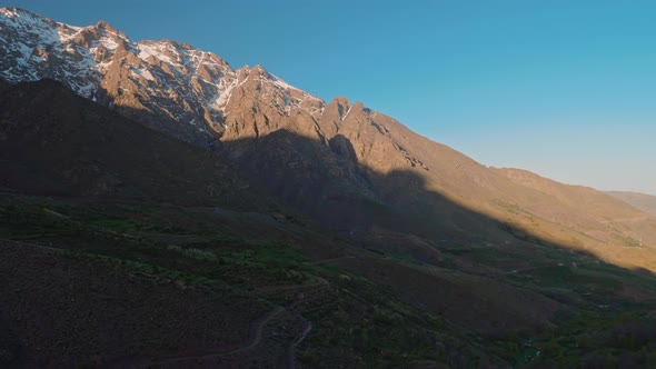 Revealing fertile valley surrounded by high atlas mountain peaks covered by snow