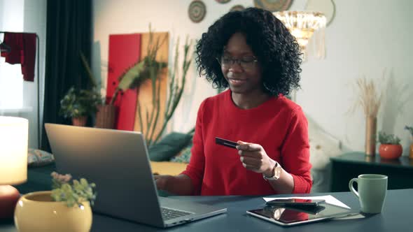 Happy Dark-skinned Lady Is Shopping Online in Self-isolation