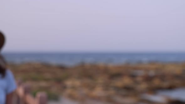 Happy teenage girl in straw hat walking along sea shore, enjoying nature, smiling and turning head