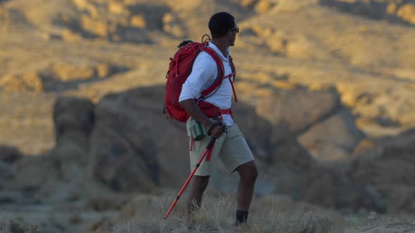 A young man backpacking in a mountainous desert