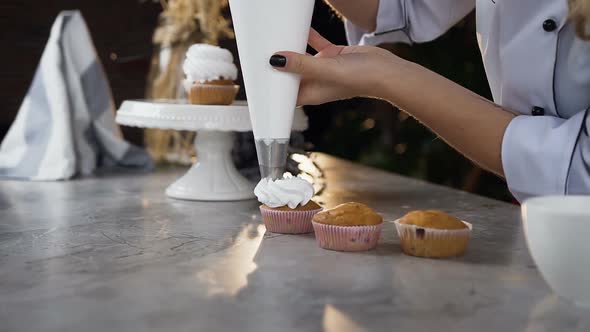 Woman Hands Using Pastry Bag to Putting Cream on the Cake