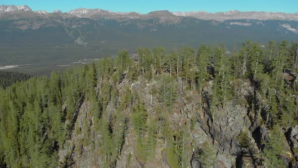 Aerial Drone View Flight over pine tree forest in Mountain during the day, Banff Canada