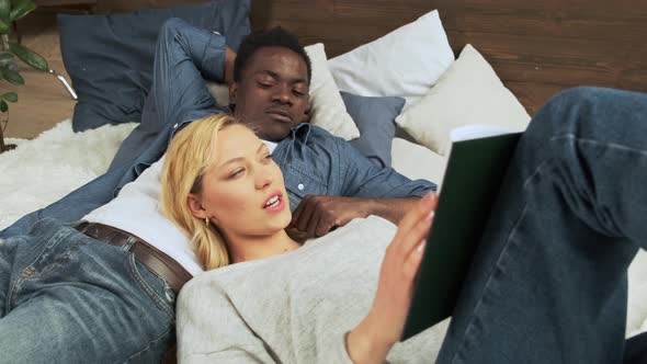 Mixed Race Couple Spend Their Leisure Time Together Lying on the Bed