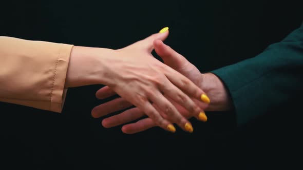 Two Businessmen Shake Hands on a Black Background Good Deal