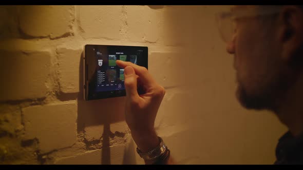 Man Checking Security Camera Through Home Hub