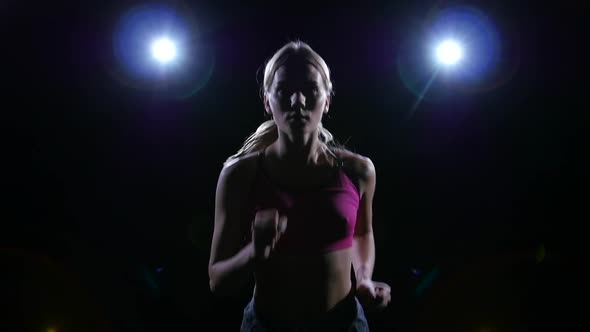 Semicircular Shooting From Left To Right Running Adorable Woman Backlit on Black Background