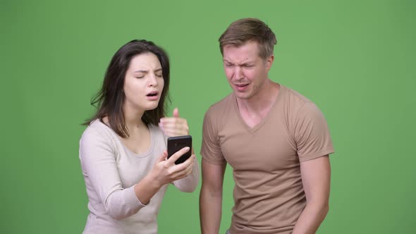 Young Couple Using Phone and Getting Bad News Together