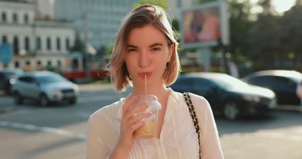 Woman Drinking Cold Latte in a City