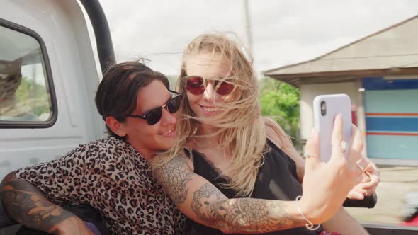 Happy Couple Taking Selfie while Riding in Back on Pickup Truck in Bali