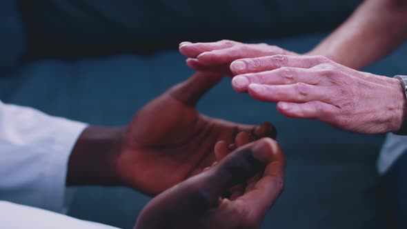 Close Up African American Black Doctor Holding Hand of Elderly Caucasian Woman