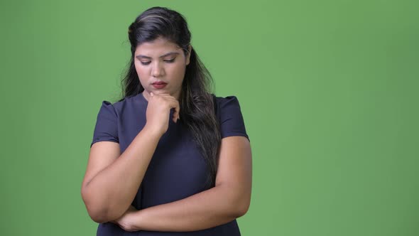 Young Overweight Beautiful Indian Businesswoman Against Green Background