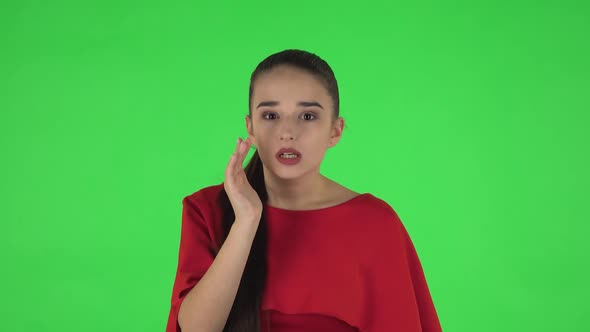 Portrait of Pretty Young Woman Is Looking Around, Covering Her Mouth with Her Hand and Whispering