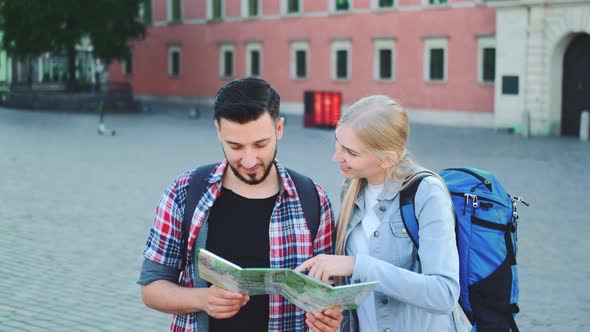 Two Tourists with Map Looking for New Historical Place in City Center