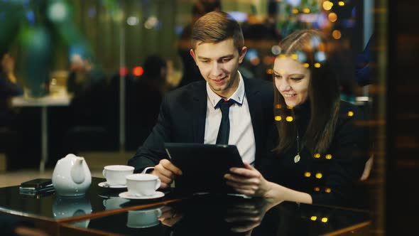 A Couple in Love Rests in a Cafe Uses a Tablet