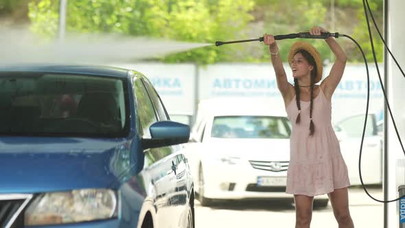 Brunette From a Highpressure Hose Washes the Car