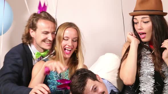 Two cute couples having fun in party photo booth