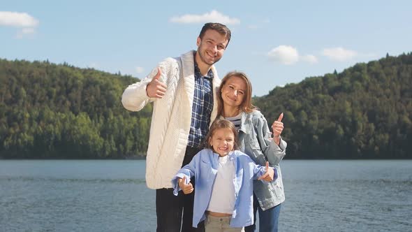 Portrait of a Young Family on the Background of a Lake