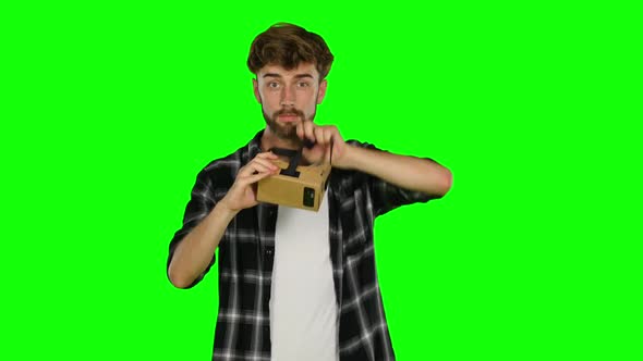 Man in Virtual Reality Is Smilling and It Makes Him Laughing. Green Screen