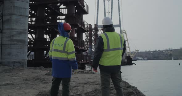 Male Engineers Examining Bridge Over River
