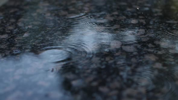 Raindrops in Slow Motion Fall on a Granite Surface