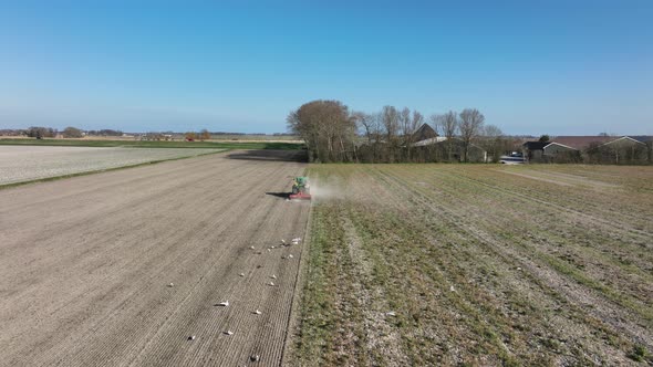 Farming Tractor Plowing Activity By a Farmer in a Tractor in the Spring Season