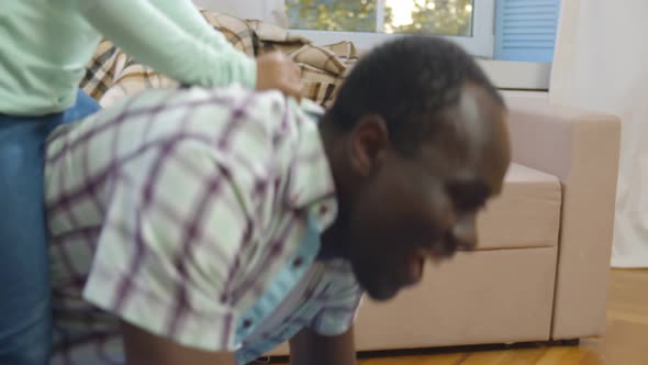 Happy Black Father Giving Piggyback Ride To Overjoyed Little Daughter.