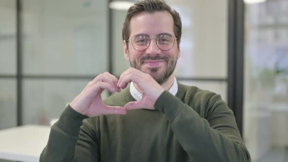 Portrait of Young Businessman Showing Heart Shape By Hands