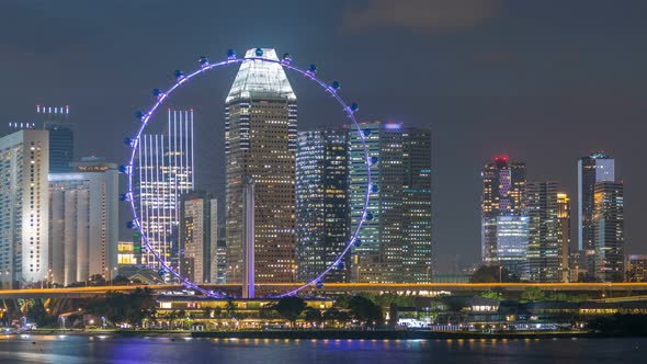 Skyline of Singapore with Famous Singapore Ferries Wheel at Night Timelapse