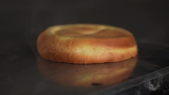 Chef toasting a burger bun with butter. Cook turns burger bun over spatula.  Slow motion macro shot.