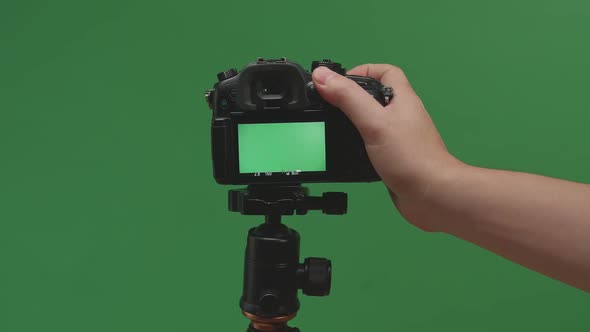 Male Hand Taking Photos With Green Screen Display Camera In Green Background