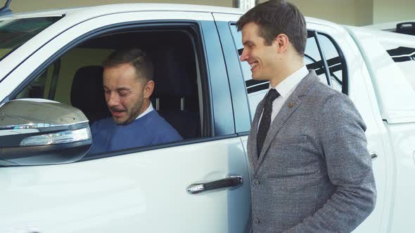 A Handsome Buyer Makes a Selfie with a Seller From the Car