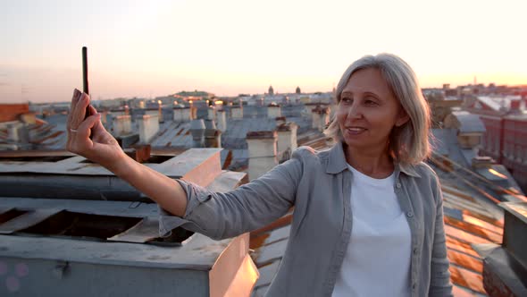 Grey-haired Middle-aged Woman Making Selfie on Roof