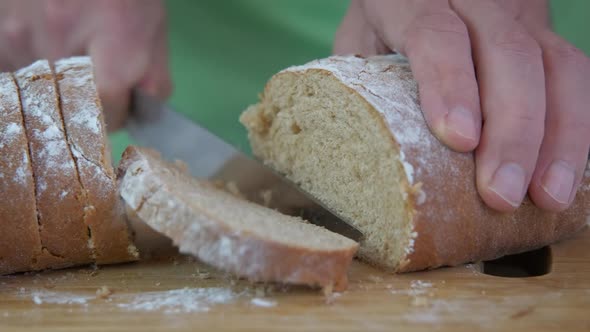 Slicing white bread with knife. 