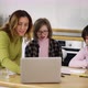 Teacher Teaches Young Girls with Down Syndrome to Use a Laptop at the Kitchen - VideoHive Item for Sale