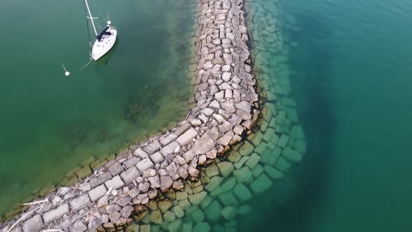 White Boat Floating And Anchored Near The Harbor By The Lake Michigan In Leland, Michigan, USA.  - a