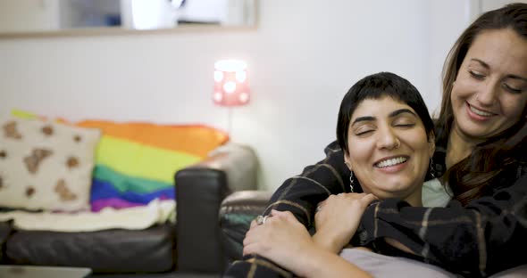 happy lesbian couple smiling and relaxing on the sofa