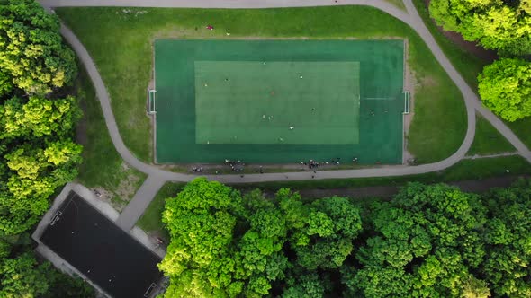 Aerial View of Men Playing Football on a Public City Soccer Field