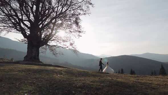 Newlyweds. Caucasian Groom with Bride on Mountain Slope. Wedding Couple. Happy