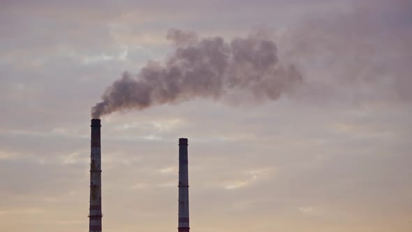 Factory chimneys with smoke. Beautiful sunset over river. View from the top.