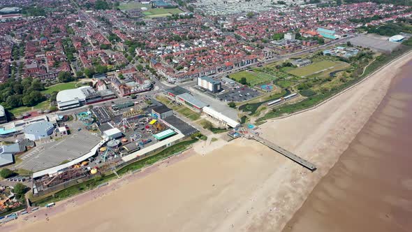 Static aerial footage of the town centre of Skegness showing the pier on the sandy beach 