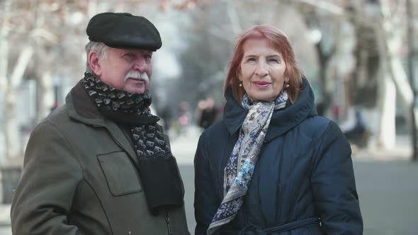 Jolly Old Man and His Smiling Senior Woman Standing in a Park in Slow Motion   