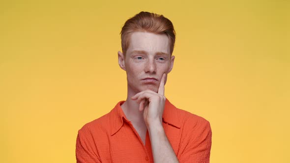 Pensive Red Haired Man Holding Hand Near Face and Nodding