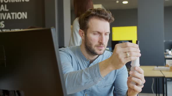 Focused Adult Man Disassembling Detail in Office