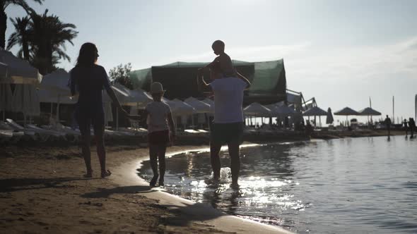 Silhouette of Active Family Having Fun and Enjoying Togetherness on the Beach at Sunset.